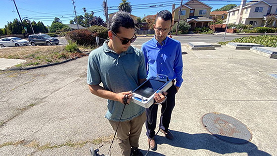 Hassan Davani (right) and Kian Bagheri, a graduate student in Davani’s lab, collect shallow groundwater table data around vulnerable sewer infrastructure