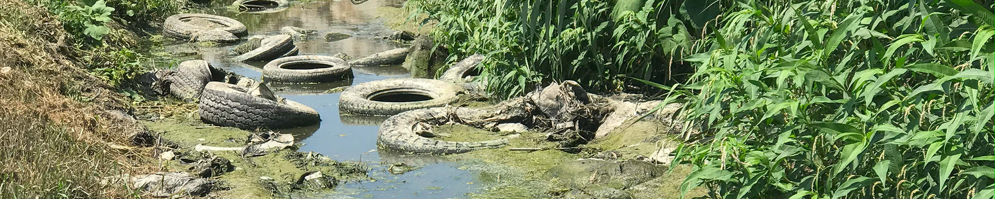 old tires and trash in the Tijuana River channel